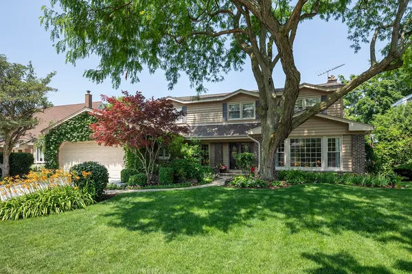 a front view of a house with a yard and trees