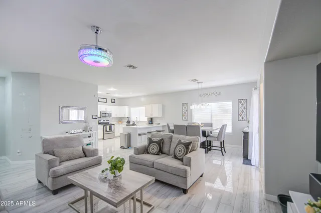 a living room with furniture kitchen view and a large window