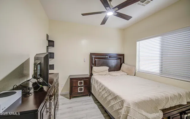 a bedroom with a bed and wooden floor