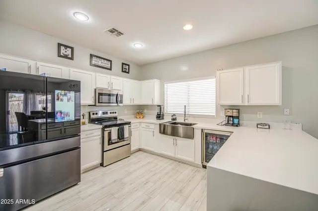 a kitchen with cabinets wooden floor and stainless steel appliances