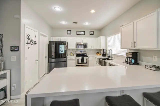 a kitchen with stainless steel appliances granite countertop a refrigerator sink and cabinets