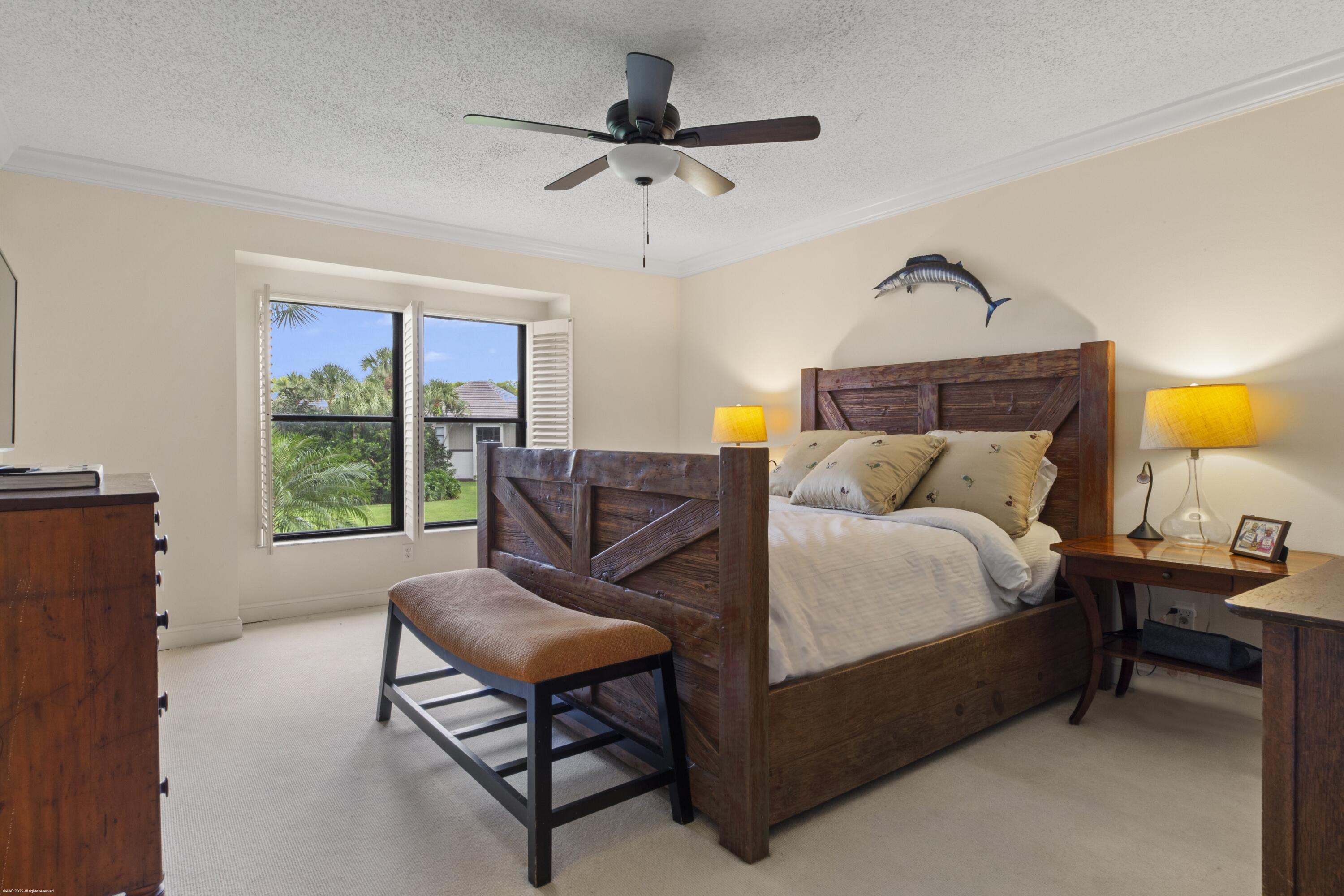 13244 Polo Club Road, Unit C206 Wellington, FL 33414 - Photo 15 of 46 a bedroom with a bed and a chandelier