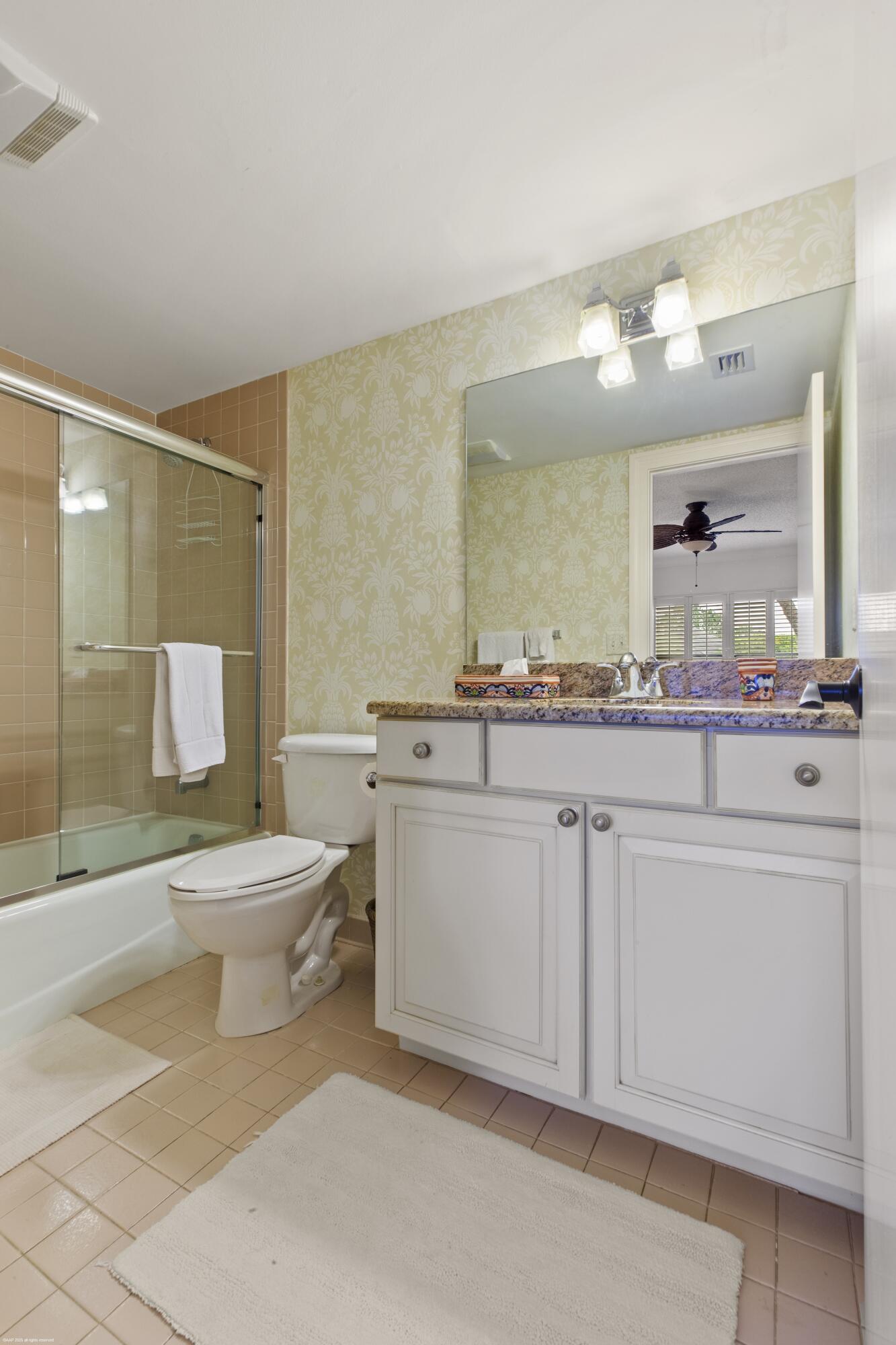 13244 Polo Club Road, Unit C206 Wellington, FL 33414 - Photo 20 of 46 a bathroom with a sink a toilet and a mirror