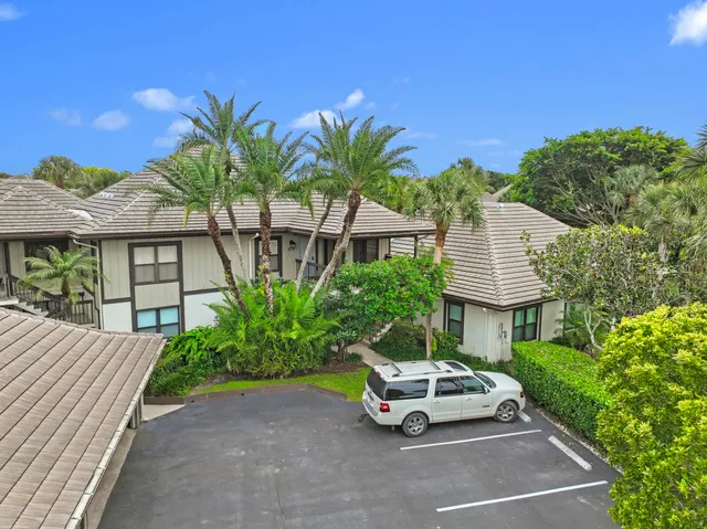 a car parked in front of a house with potted plants