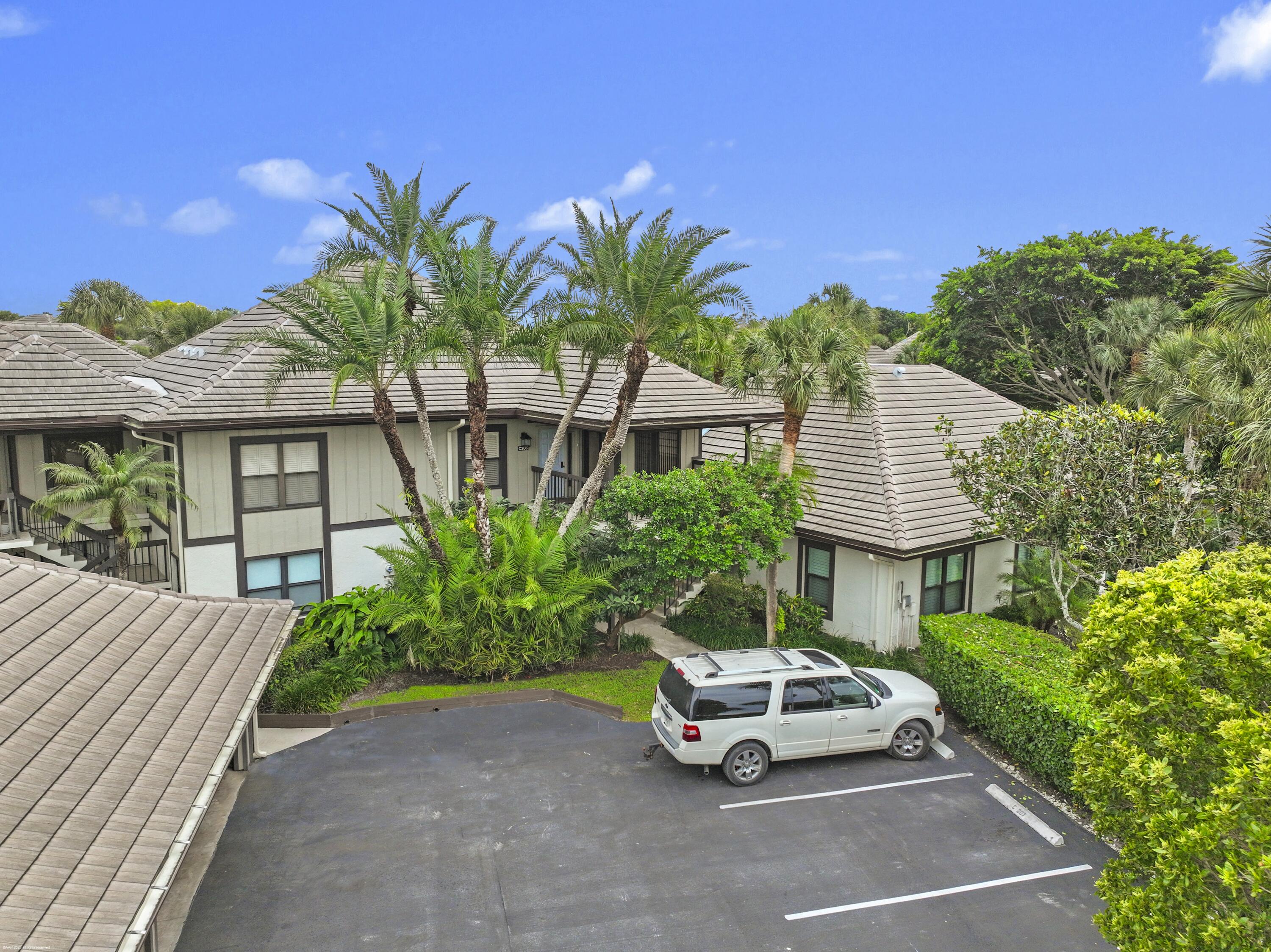13244 Polo Club Road, Unit C206 Wellington, FL 33414 - Photo 29 of 46 a car parked in front of a house with potted plants
