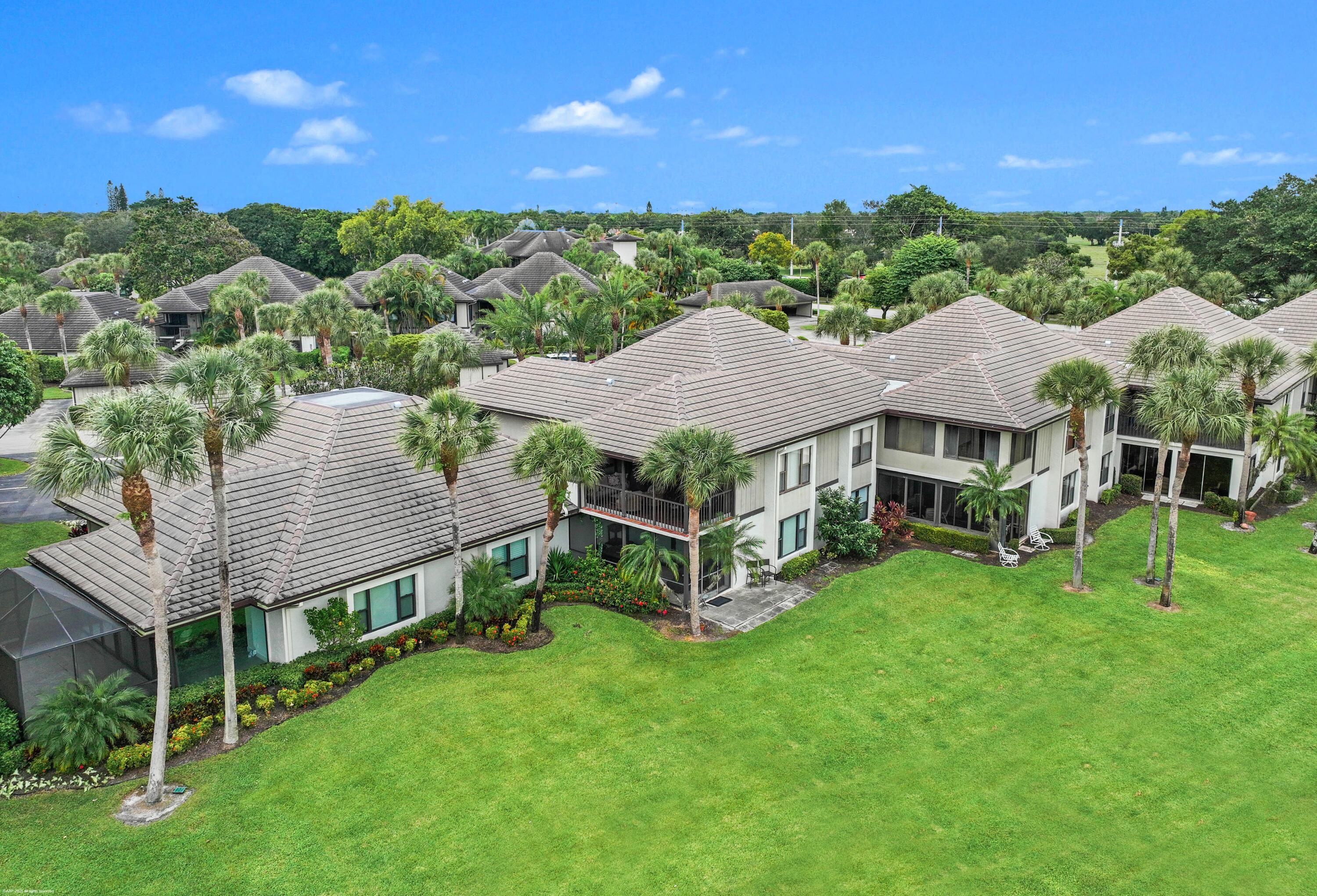13244 Polo Club Road, Unit C206 Wellington, FL 33414 - Photo 34 of 46 a view of a house with a big yard and large trees
