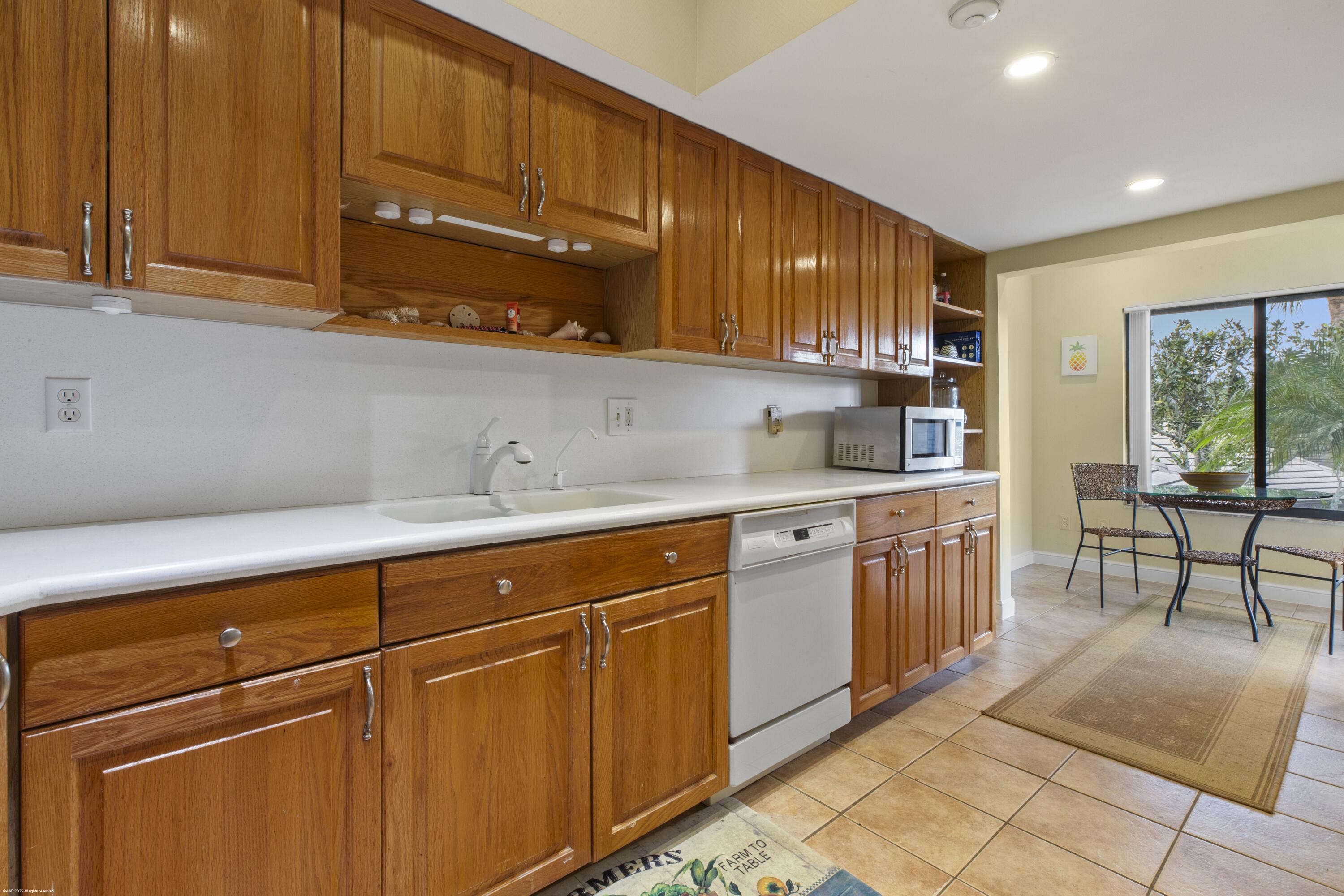 13244 Polo Club Road, Unit C206 Wellington, FL 33414 - Photo 5 of 46 a kitchen with stainless steel appliances granite countertop wooden cabinets a sink and dishwasher