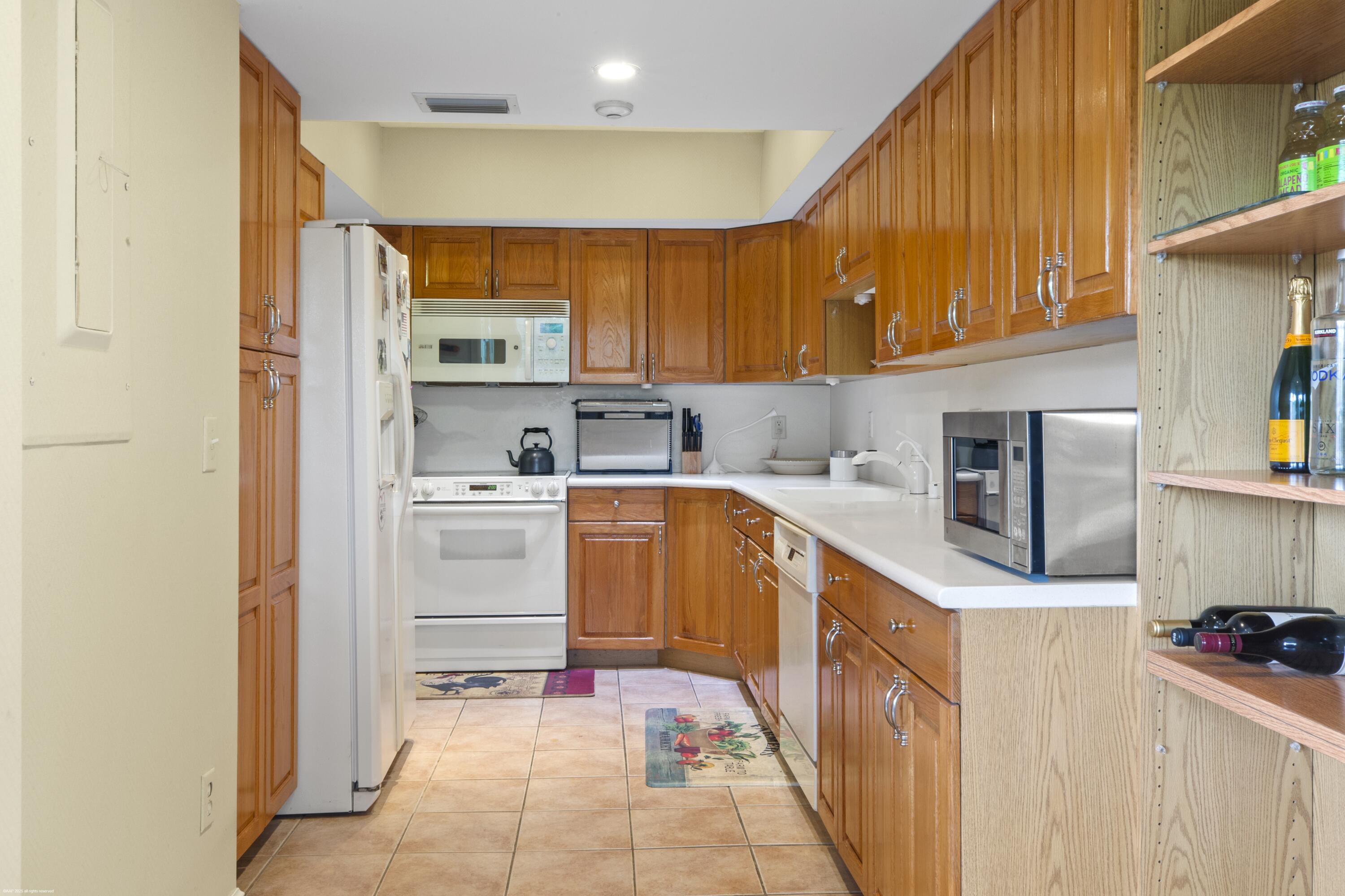 13244 Polo Club Road, Unit C206 Wellington, FL 33414 - Photo 6 of 46 a kitchen with stainless steel appliances granite countertop a sink and cabinets