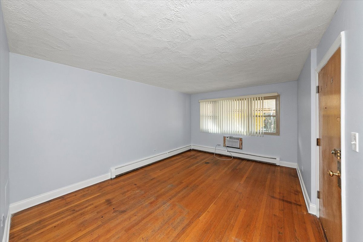 335 Custer Avenue, Unit 2S Evanston, IL 60202 - Photo 3 of 10 a view of an empty room with wooden floor and a window