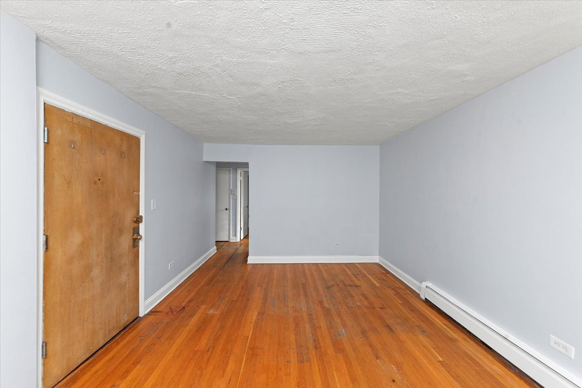 335 Custer Avenue, Unit 2S Evanston, IL 60202 - Photo 6 of 10 a view of a room with wooden floor and brick walls
