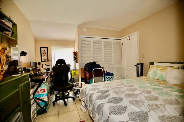 a large bedroom with a bed and wooden floor