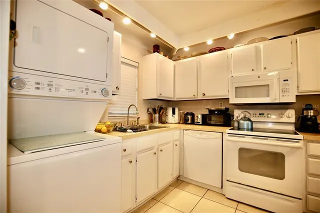 a kitchen with stainless steel appliances granite countertop a sink a stove and white cabinets