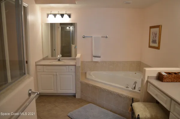 a bathroom with a tub sink and mirror