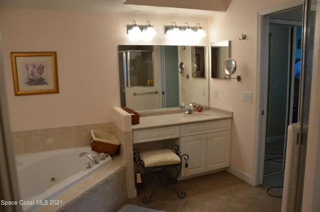 a bathroom with a tub sink and mirror