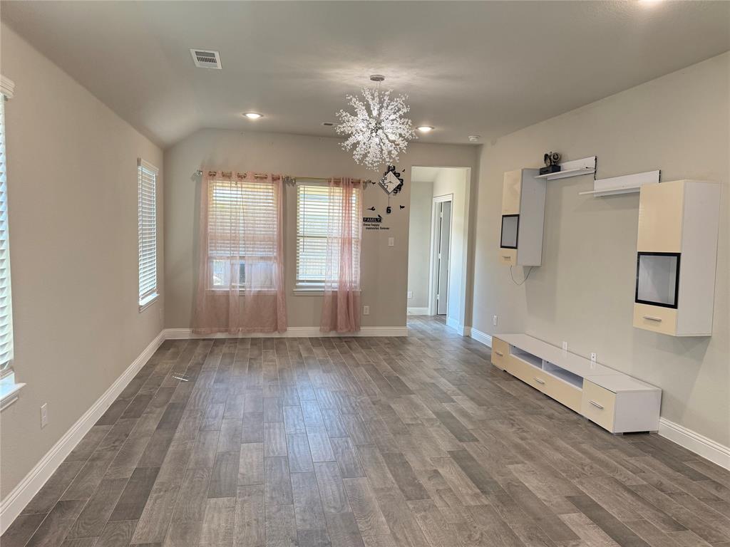 1659 Timpson Drive Forney, TX 75126 - Photo 3 of 10 a view of an empty room with wooden floor and a window