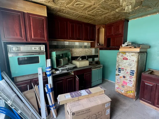 a kitchen with a refrigerator and a stove top oven