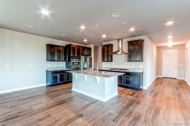 a kitchen with sink stove and wooden floor
