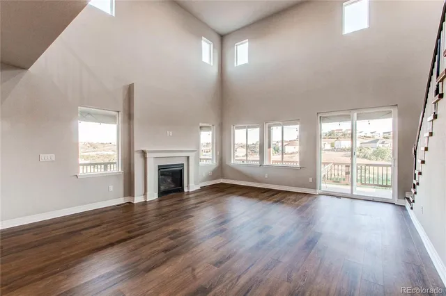 a view of staircase and kitchen with stove and wooden floor