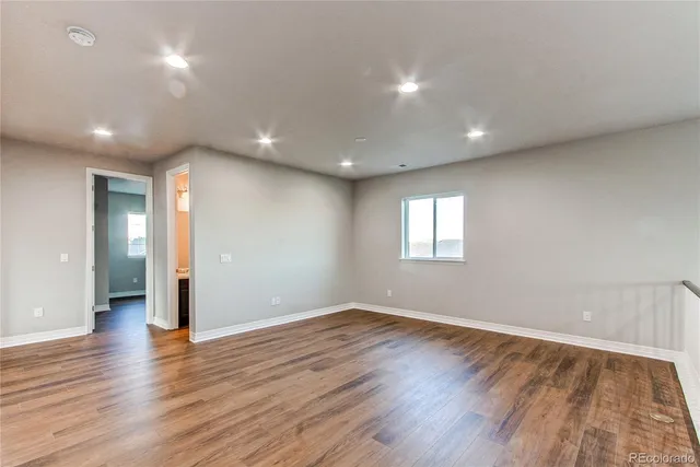 a view of an empty room with wooden floor