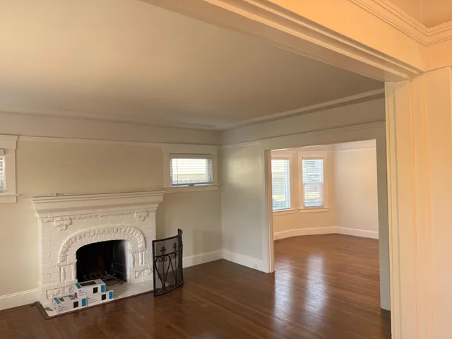 a living room with wooden floor and a fireplace