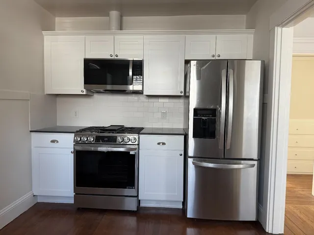a kitchen with stainless steel appliances a refrigerator microwave and stove