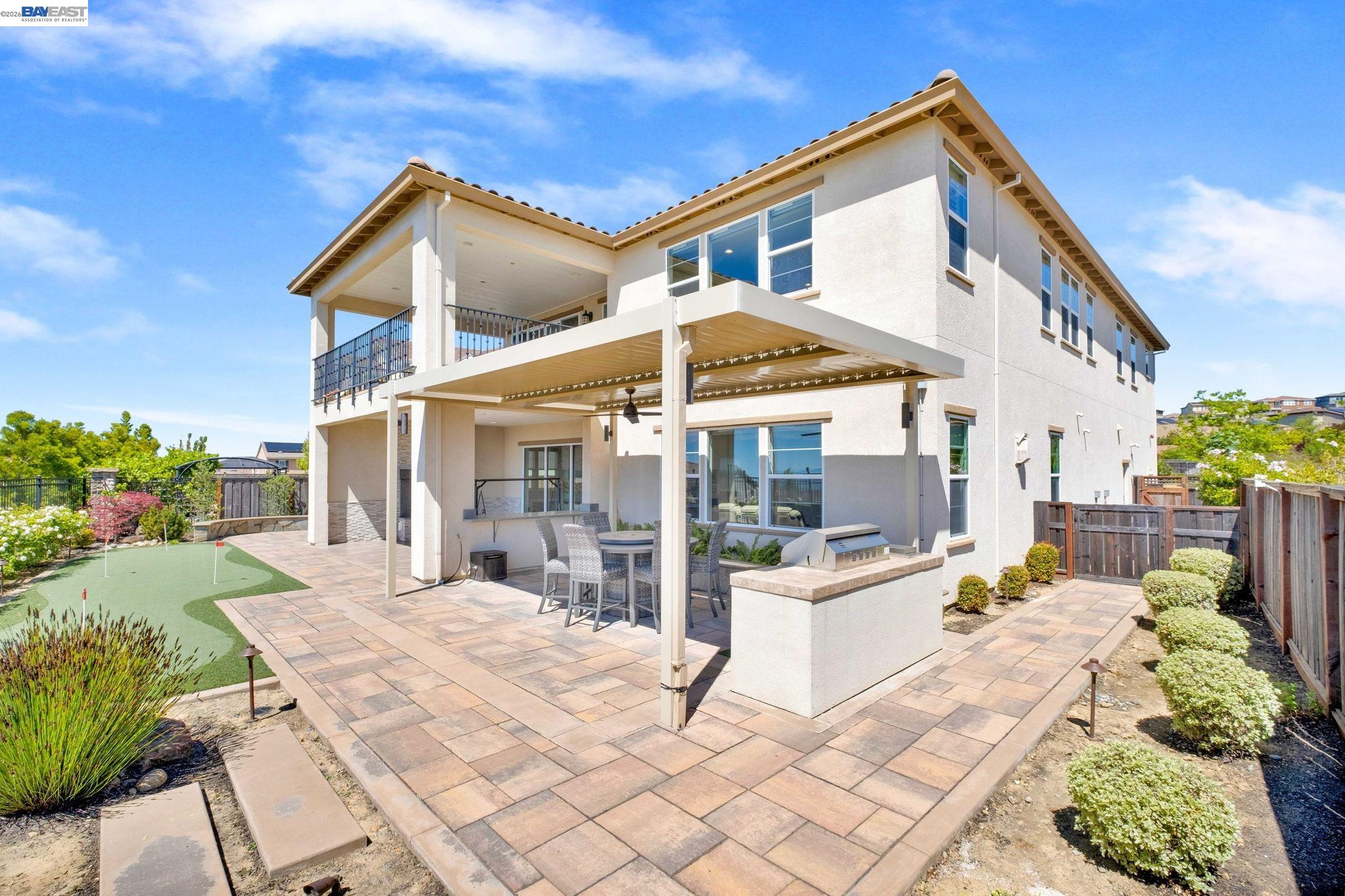 128 Dunfirth Drive Hayward, CA 94542 - Photo 40 of 60 a view of a white house with a yard and lawn chairs under an umbrella