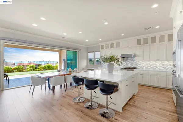 a kitchen with granite countertop kitchen island stainless steel appliances a sink and cabinets