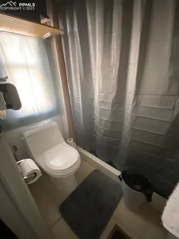 a white toilet sitting next to a shower curtain