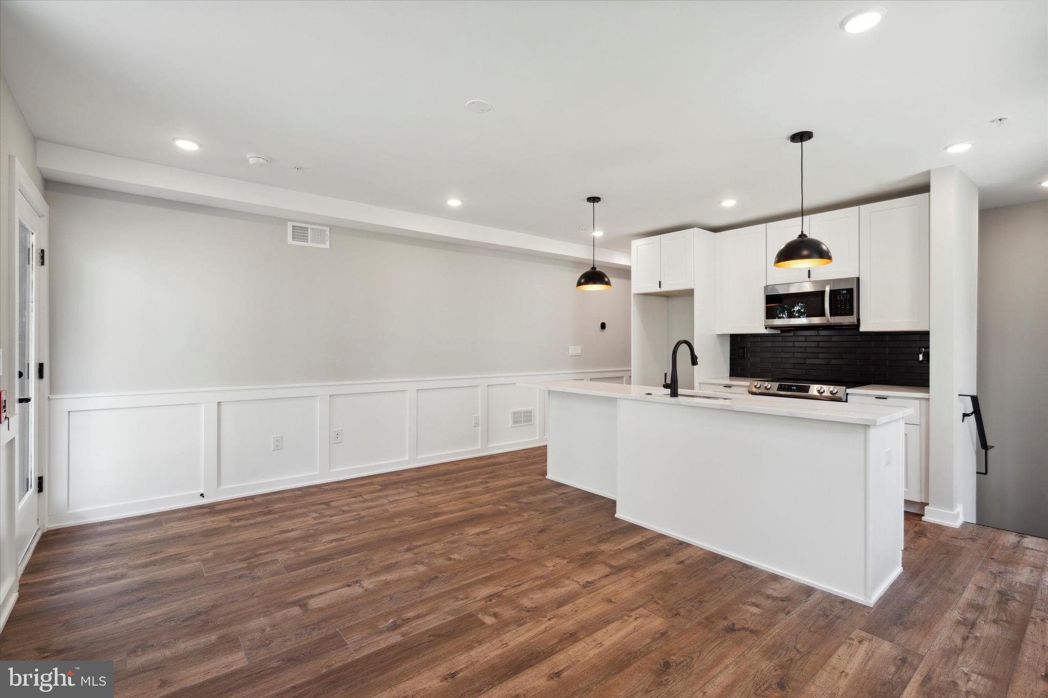 3519 Hamilton Street, Unit B Philadelphia, PA 19104 - Photo 9 of 16 a large white kitchen with cabinets a sink and a stove