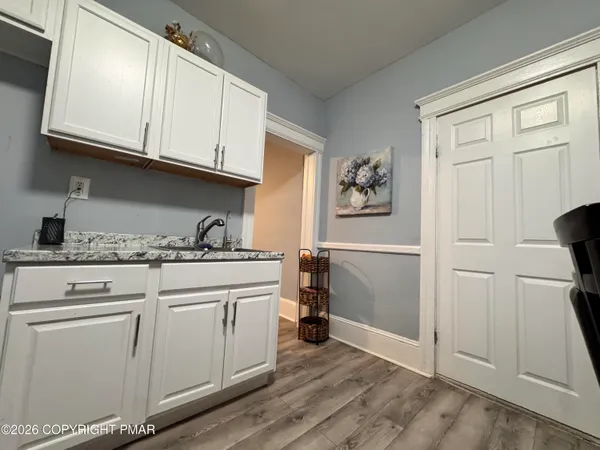 a kitchen with cabinets appliances and a wooden floor