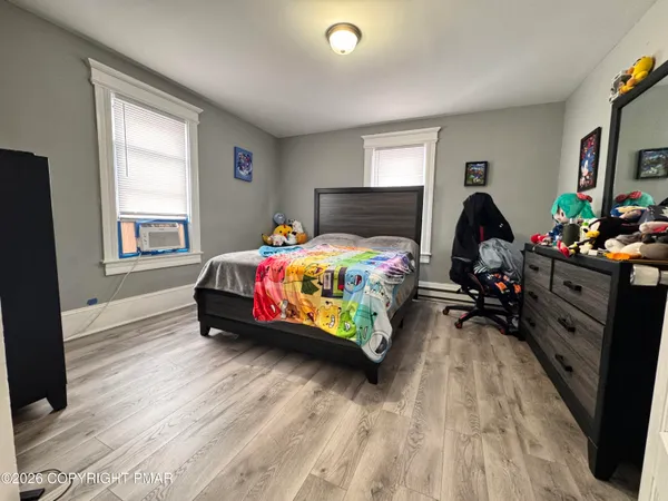 a bedroom with a bed table closet and a window