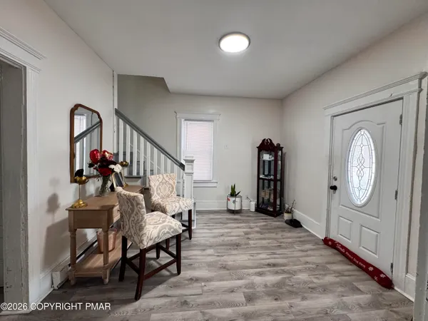 a living room with furniture a mirror and wooden floor