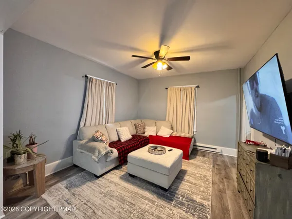 a living room with furniture chandelier and a flat screen tv