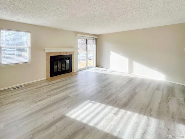 a view of empty room with wooden floor and fireplace