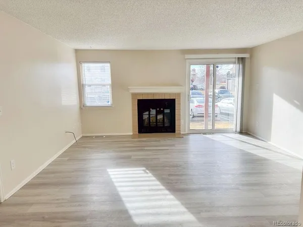 wooden floor fireplace and windows in an empty room