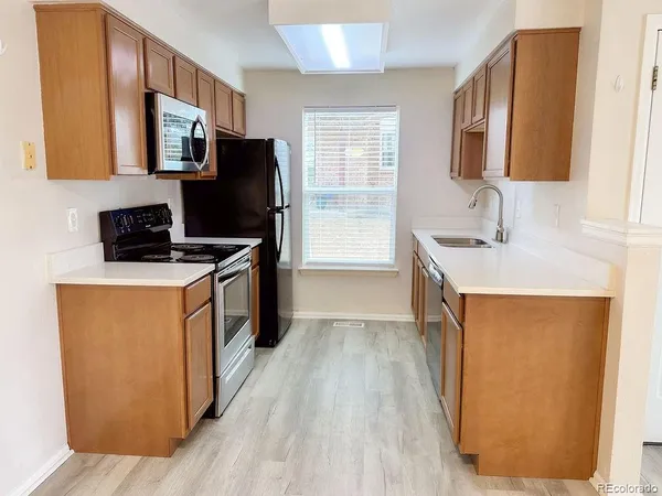 a kitchen with stainless steel appliances granite countertop a stove a sink a refrigerator and a microwave