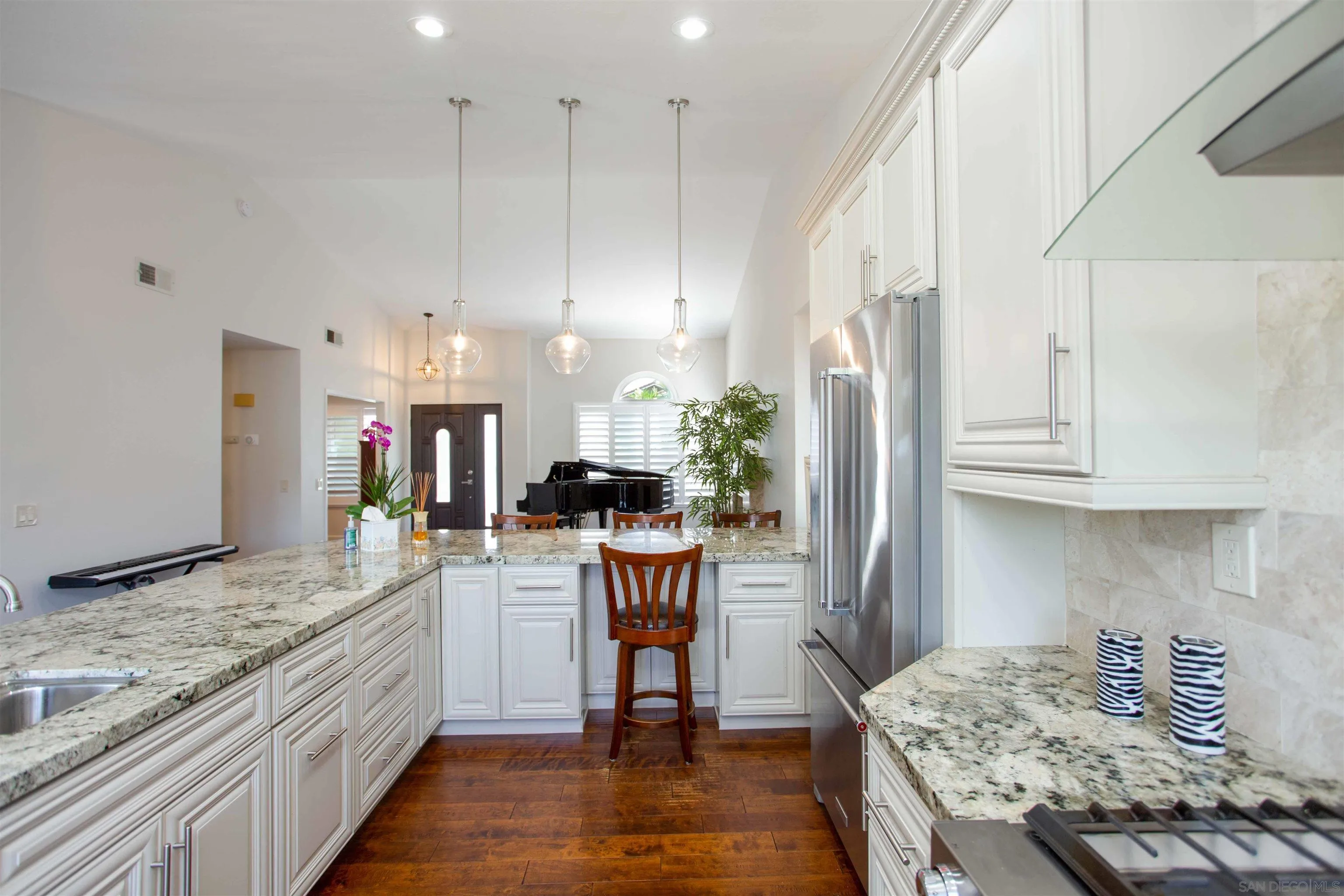 9182 Emden Road San Diego, CA 92129 - Photo 11 of 27 a kitchen with kitchen island granite countertop wooden cabinets and a refrigerator