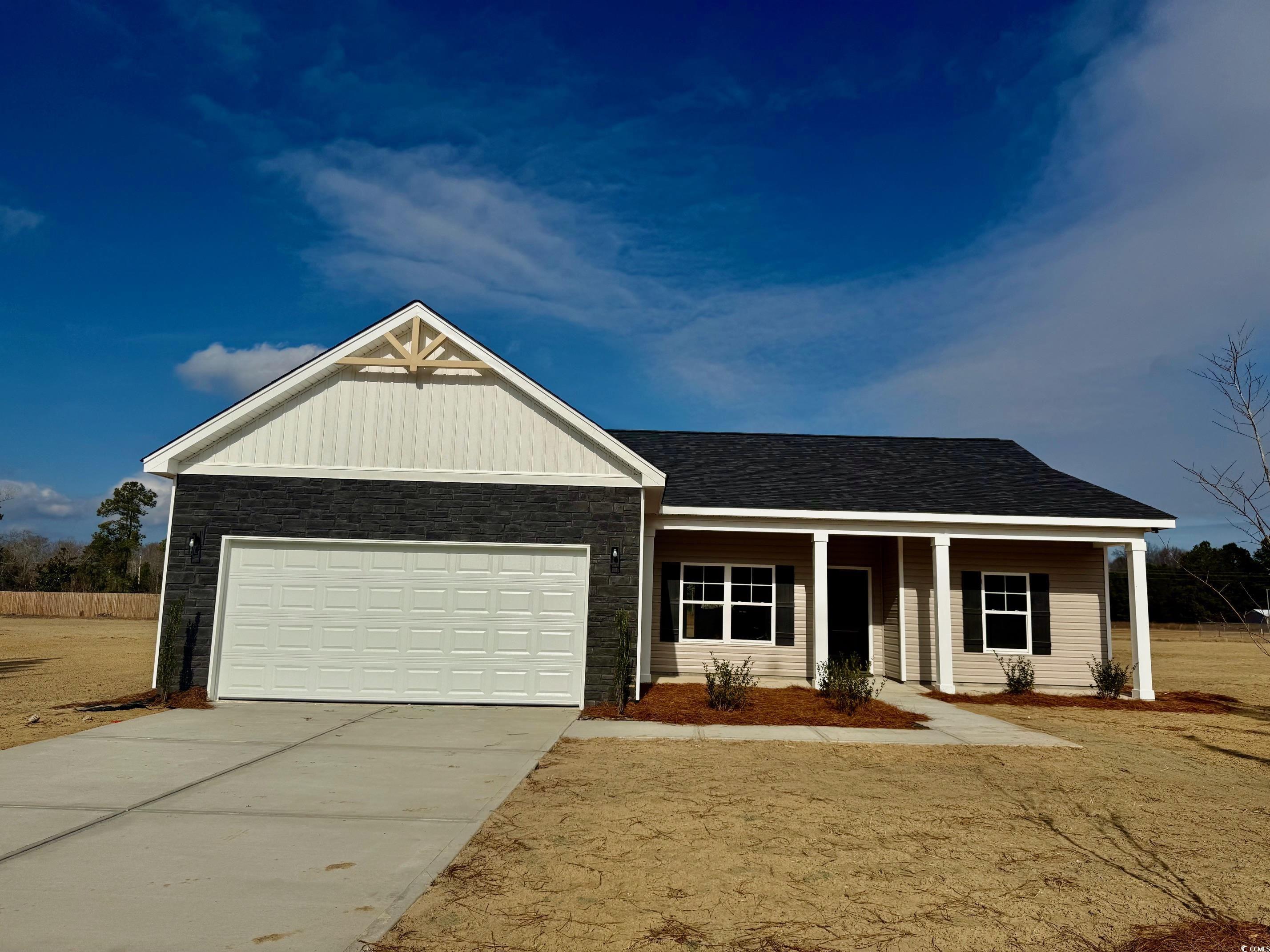 Ranch-style house with covered porch, concrete driveway, stone siding, an attached garage, and roof with shingles