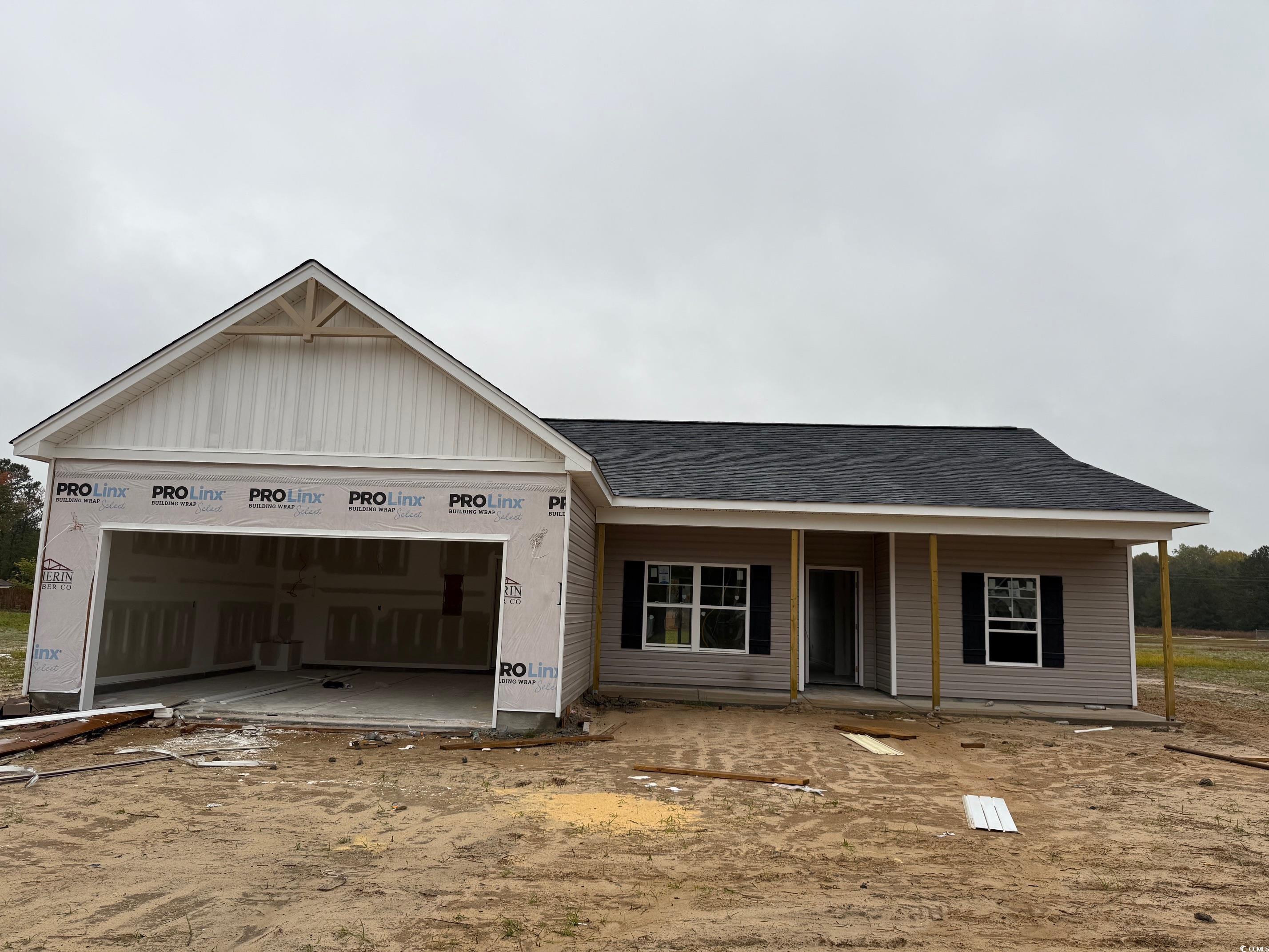View of front of home featuring a porch, a garage, and roof with shingles
