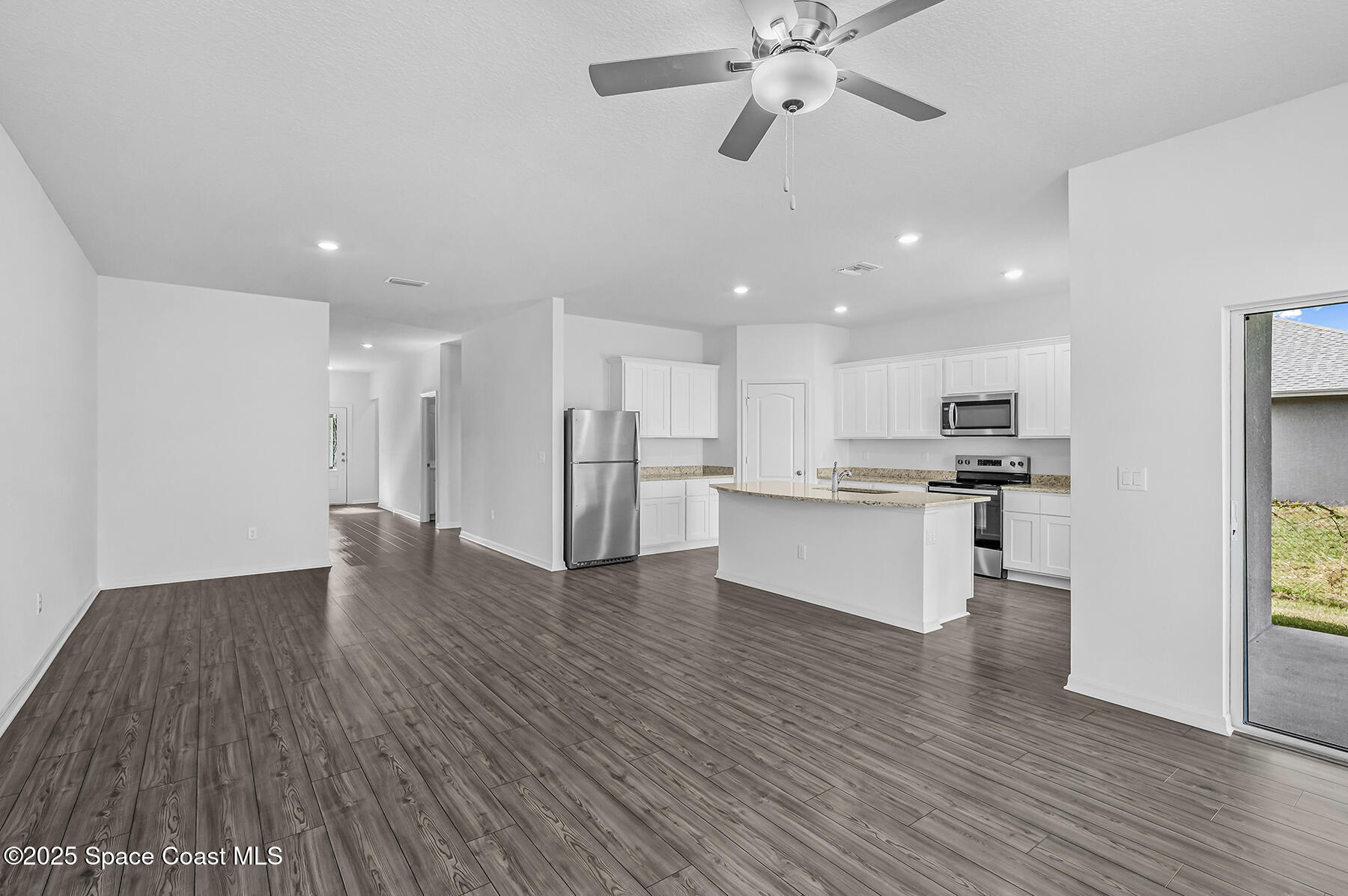 435 Olney Street Palm Bay, FL 32908 - Photo 4 of 18 a view of kitchen with refrigerator microwave and stove with wooden floor