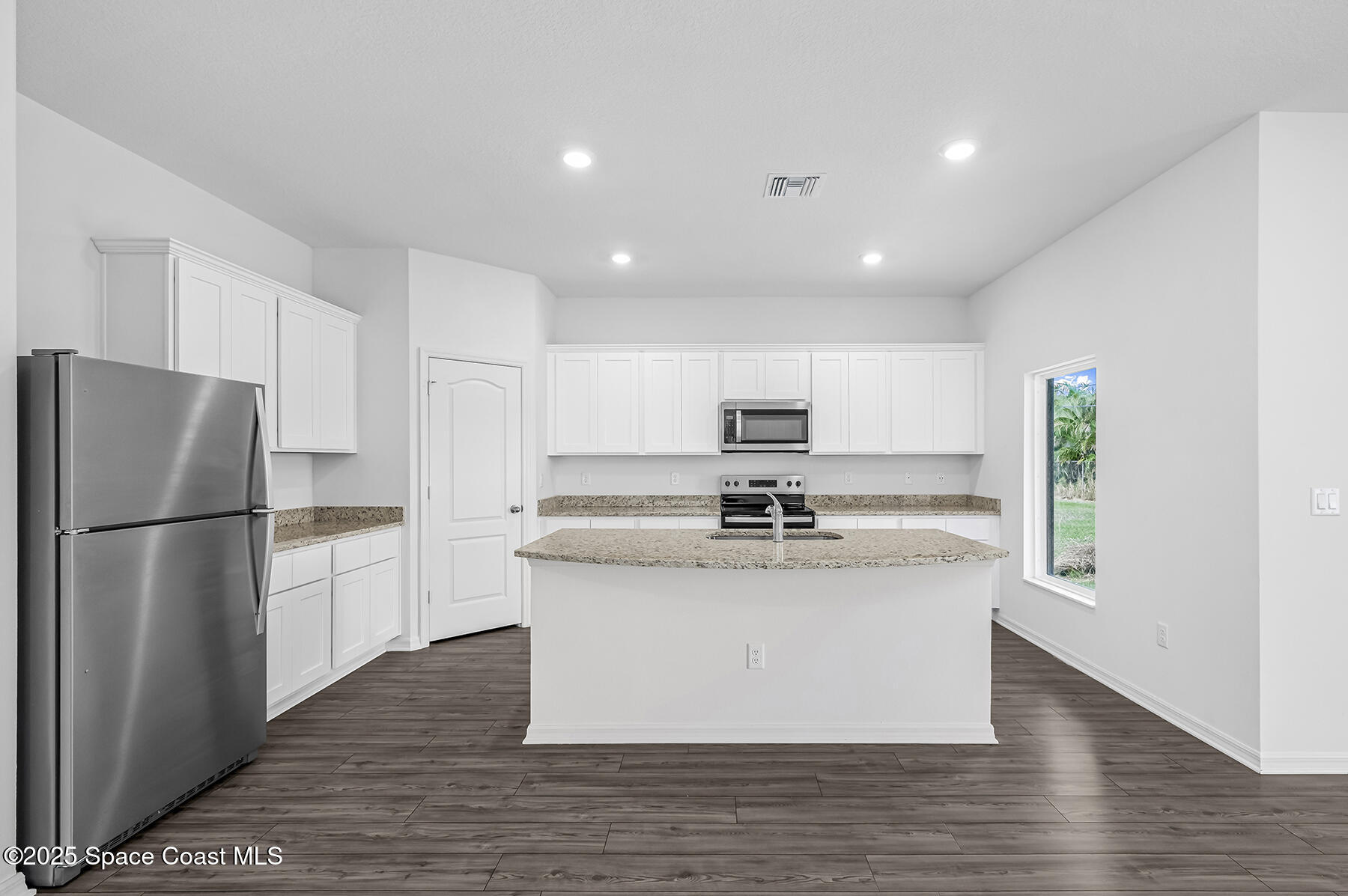 435 Olney Street Palm Bay, FL 32908 - Photo 6 of 18 a kitchen with stainless steel appliances a refrigerator sink and stove