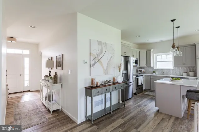 a kitchen with kitchen island white cabinets and stainless steel appliances