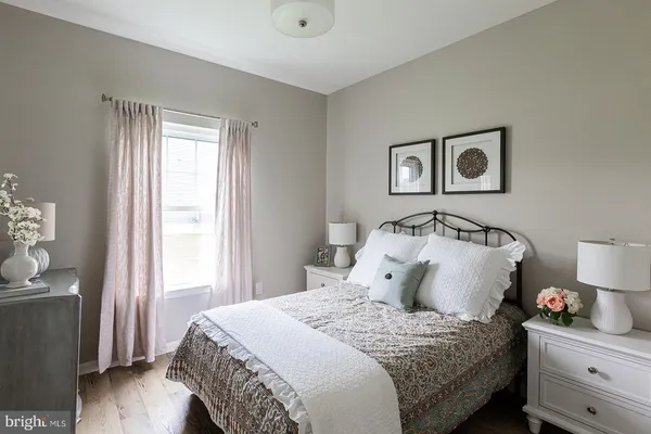 a bedroom with bed and wooden floor