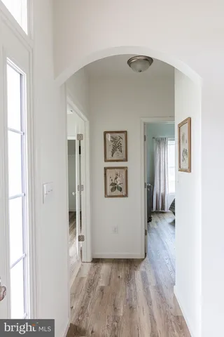 a view of a hallway with wooden floor and closet