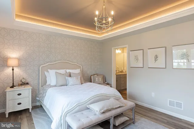 a spacious bedroom with a bed and a chandelier