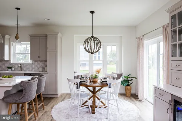 a dining room filled chandelier and kitchen view