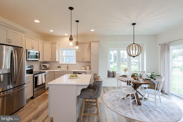 a kitchen that has a lot of cabinets stainless steel appliances and a chandelier
