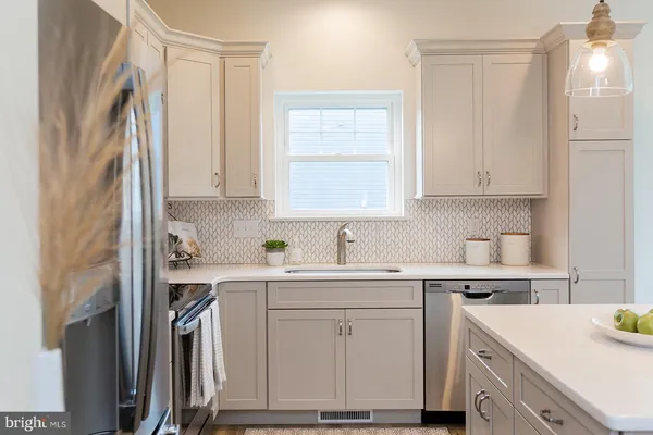 a kitchen with cabinets appliances a sink and a window