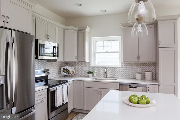 a kitchen with stainless steel appliances granite countertop a sink a stove cabinets and a refrigerator