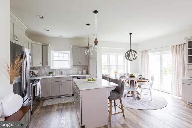 a view of a dining room and livingroom with furniture wooden floor a chandelier
